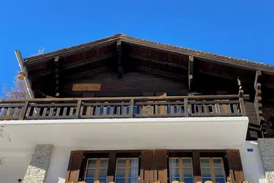 Image de Chalet confortable pour 5-7 personnes : Living avec fourneau à bois et canapé-lit - cuisine - machin