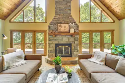 Image de Timber Ridge Lake House is a private lake home in Amery Wisconsin. The home balances the warmth of a large A-Frame with modern decor and finishes providing a serene stay with woods and lake views.