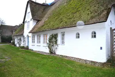 Image de This vacation apartment is located on the top floor of an old thatched building