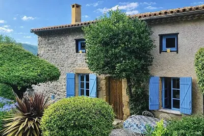 Image de Maison en pierre de caractère, nichée dans un cadre verdoyant.