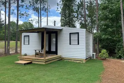 Image de Modern tiny house with large outdoor area and grill.