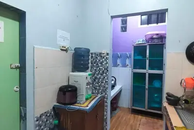 Image de Rumah dua lantai berwarna biru cerah tampak bercahaya di malam hari