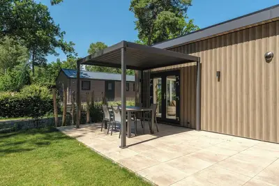 Image de Stay in a luxurious holiday home for 4 people in the heart of the forested Veluwe, featuring modern amenities, air conditioning, a stylish pergola, and where pets are welcome.