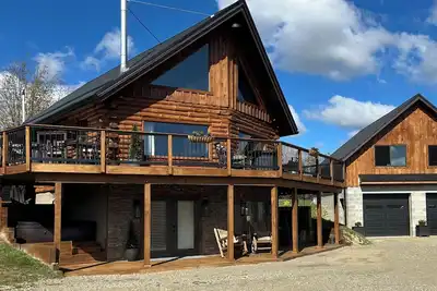 Image de Enjoy an updated classic log cabin with ski slope views from the hot tub.