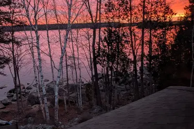 Image de Stunning lakefront home with serene outside sitting area overlooking the water.