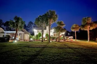 Image de Resort style 5-bedroom lake house with white sand beach, pool, and pool house.