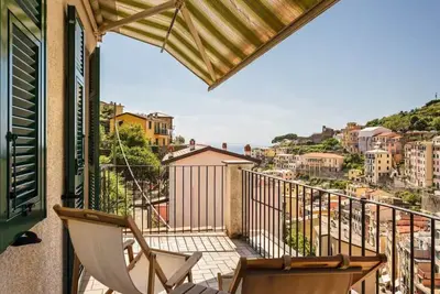 Image de GuestHost - Roomy 110 sqm apartment with balcony and terrace, which can accommodate up to 6 people, organized on two levels and located on the first floor (No lift, 10 external steps to access to it). The property, overlooking the village and the sea, is