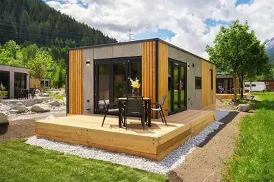 Image de Discover the Rosanna Cabin at Camping Arlberg, a stylish and sustainable accommodation surrounded by nature. Enjoy comfort and tranquility with stunning views of the Alps. The perfect place for a relaxing stay, all year round.