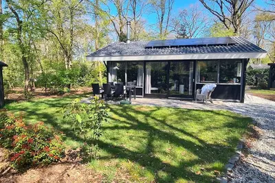 Image de The De Bosduif bungalow accommodates four people and is situated in a very open and spacious setting. The luxurious furnishings make your stay especially comfortable. The beautiful glass wall with French doors brings the outdoors inside.