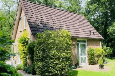 Image de This “Tortelduif” 4-person bungalow is a charming vacation home where peace, privacy, and comfort take center stage. <br>It offers plenty of privacy thanks to the surrounding trees and features a cozy living room, a fully equipped kitchen, and two com