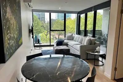 Image de Stay in the heart of Canberra in style. Enjoy resort-style pools, rooftop gardens, and a private terrace. Perfectly positioned opposite Canberra Center, this modern retreat features secure parking, high-speed WiFi, and a fully equipped kitchen!