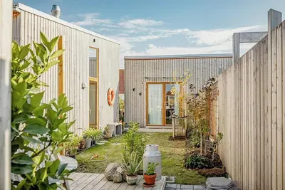 Image de Maison moderne en bois au milieu des pommiers avec vue sur la mer