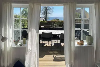 Image de Maison en bois au toit de chaume avec vue sur la mer à Kelstrup Strand