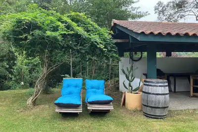 Image de Maison conviviale entourée de verdure.