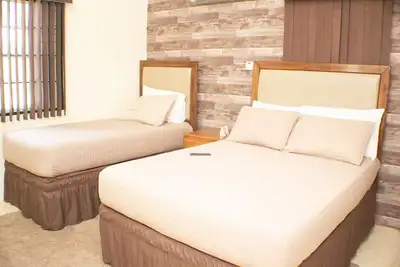Image de Profitez d’un séjour en famille dans notre suite spacieuse de 2 chambres avec grand salon et cuisine entièrement équipée. Dotée de la climatisation et de ventilateurs de plafond, elle est idéale pour se détendre et partager de bons moments.