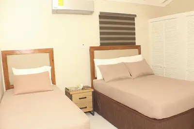 Image de La Suite Familiale 6 offre un espace chaleureux avec deux lits doubles, deux lits simples, un fauteuil et un canapé. Profitez de la vue sur The Vista Inn South, d’une télévision à écran plat, du Wi-Fi haut débit et de services de streaming.
