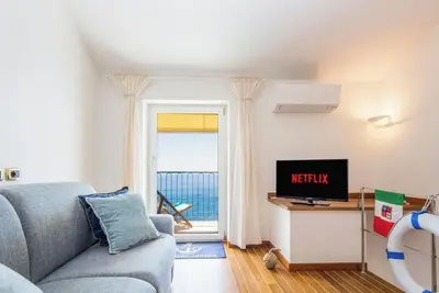 Image de “Vista Mare Genova”A two-level gem with a spectacular sea view, unique in the area. Lower floor: Bedroom with premium-quality mattress, bathroom, and a cozy corner with table and chess set overlooking the sea. Upper floor: Living room with sofa bed, fu