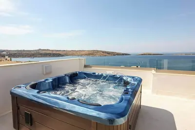 Image de Enjoy a modern 2-bedroom penthouse in St Paul’s Bay with a private terrace, jacuzzi, stunning sea views, air conditioning, lift access, and a bright open-plan living area. Perfect for couples, families, and relaxing coastal stays.