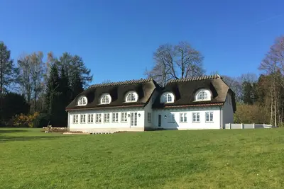Image de Un bâtiment emblématique au toit de chaume dans la forêt près du château de Valdemar