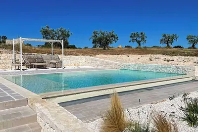 Image de Trullo avec piscine à débordement au milieu des oliviers des Pouilles