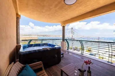 Image de Wake up to beautiful Mediterranean views in this stylish three-bedroom seafront apartment in Għadira Bay, Mellieħa. Enjoy three double bedrooms, modern interiors, excellent facilities and a private jacuzzi overlooking the bay.