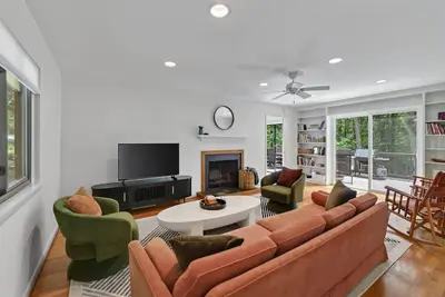 Image de Settle into this stylish 4 bedroom, 3. 5 bath midterm rental, thoughtfully designed with a warm midcentury modern vibe. Enjoy two primary suites, generous storage, a spacious deck, covered porch and private wooded backyard.
