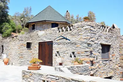 Image de Villa traditionnelle en pierre avec un moulin à vent et une piscine à Koundouros