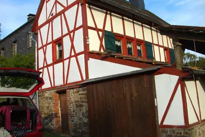 Image de maison historique à colombages à l'orée d'une forêt dans un endroit isolé