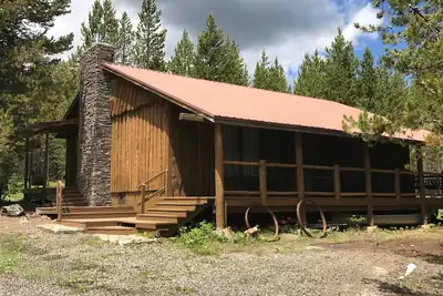 Image de Cabine bordée de porche nichée dans les pins pour les jours d'été paresseux