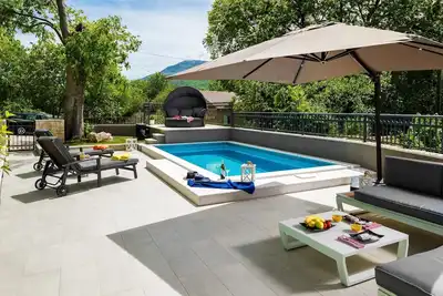 Image de Cozy House Mia, avec piscine chauffée, jacuzzi dans la piscine et barbecue. . .