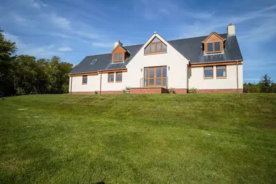 Image de Maison familiale entourée de pelouse et de bois avec vue sur la campagne