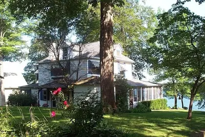 Image de Magnifique maison au bord du lac Paw Paw Waterfront avec 155 pieds de front de mer de sable et de quai
