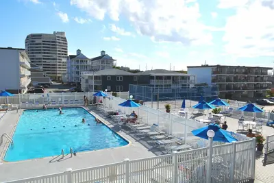 Image de Élégant, confortable condo de 2 chambres en bord de mer avec WiFi gratuit, une piscine extérieure et une salle de jeux située dans le centre-ville et à quelques pas de la plage!
