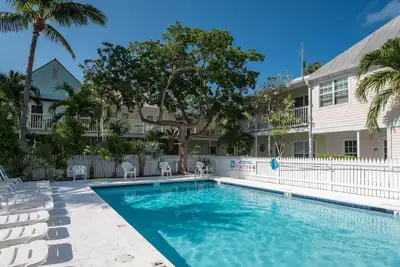 Image de Condo tropical ensoleillé avec une piscine partagée, proche de toute l'action en bord de mer
