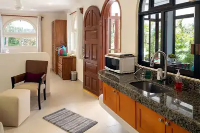 Image de Belle chambre avec lit king size, cuisine complète, canapé-lit. Demi paroi séparant.
