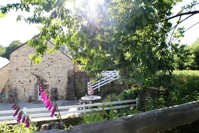 Image de Moulin restauré avec cheminée, terrasse au bord de l'eau et solarium, accueil chaleureux