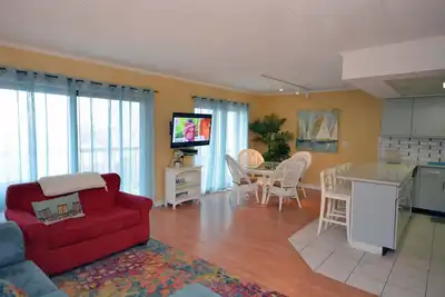 Image de Condo moderne et coloré de 2 chambres avec Wi-Fi gratuit, une piscine extérieure et de magnifiques meubles en suède surplombant les marais à couper le souffle et la baie à un pâté de maisons et demi de la plage!