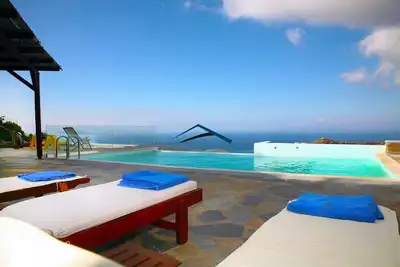 Image de Villa Ailea avec une piscine à débordement et un grand coucher du soleil et vue sur la mer.