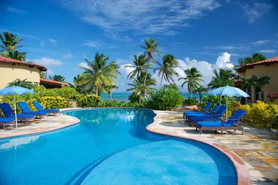 Directement sur l'eau, ombragée de palmiers, avec piscine design - un paradis privé!