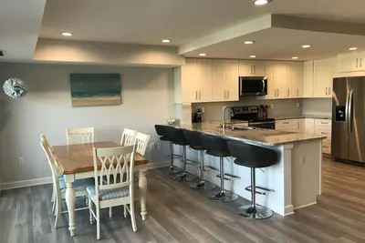 Image de Linge Et ACTIVITÉS Quotidiennes Inclus! BÂTIMENT En Bord De Mer Avec Une Piscine Sur Le Toit Une cuisine entièrement rénovée avec de nouveaux placards et appareils ménagers, un plan d'étage ouvert et un comptoir pour manger.