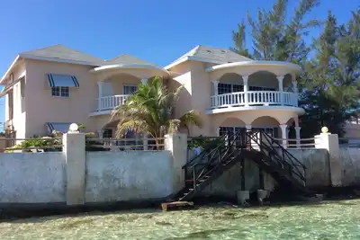 Image de Maison en bord de mer avec une petite plage de sable, une piscine et des vues fantastiques