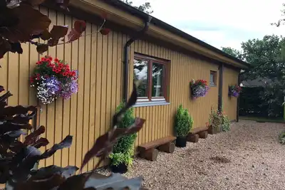 Image de Burnside Lodge, surplombant la rivière Lundy, toile de fond de Ben Nevis et Nevis Range.