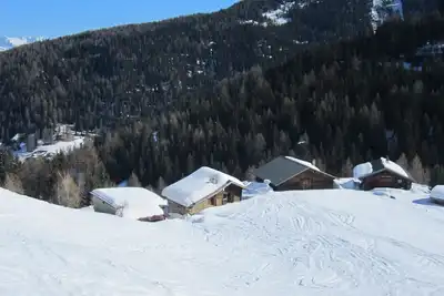 Chalet savoyard typique avec un toit en tavaillons, des murs en tuf et en fuste