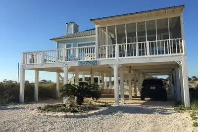Image de Lucky Dog Beach House avec cour clôturée et vue sur le golfe sur la plage Pet Friendly.