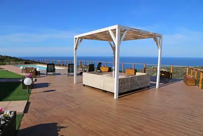 Image de Lumineuse villa avec piscine privée, entourée de pelouse et vue sur la mer