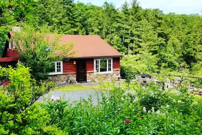 Image de Log Cabin perché au-dessus d'une chute d'eau avec vue sur la montagne