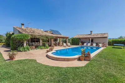 Image de La villa dispose d'un grand jardin avec une piscine rectangulaire de long.