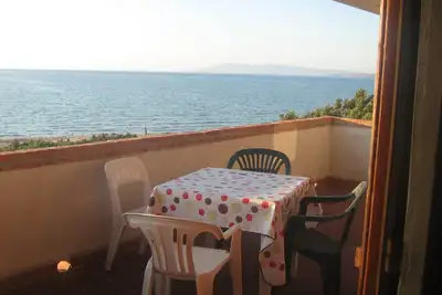 Image de Le bruit de la mer. Maison sur la plage, entourée de verdure, en Sardaigne.