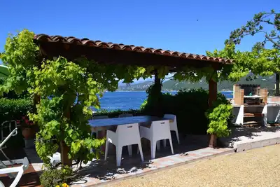 Image de Maison indépendante face à la mer surplombant une petite plage.