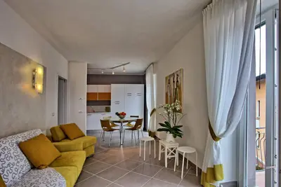 Image de Appartement avec vue panoramique sur les eaux bleues du lac de Côme et ses montagnes verdoyantes.